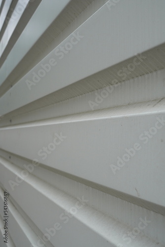 PVC white grooved wall fencing construction site. Converging grooves pattern background