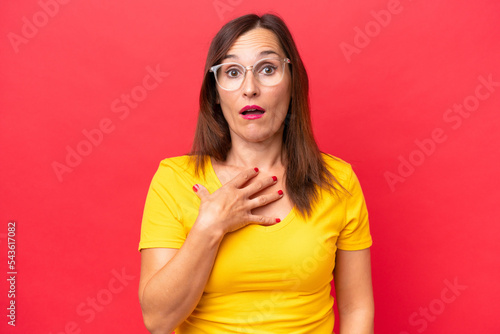 Middle-aged caucasian woman isolated on red background surprised and shocked while looking right