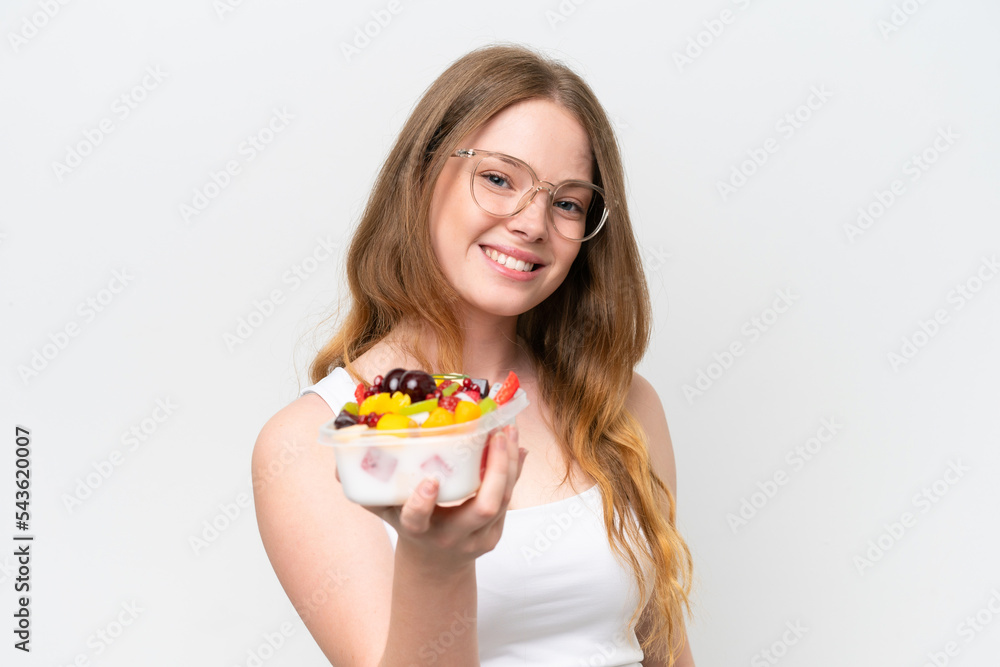 Young pretty woman holding a bowl of fruit isolated on white background with happy expression