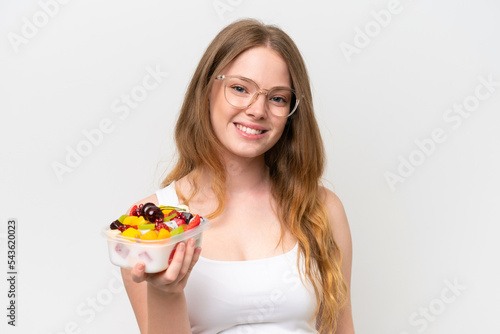 Young pretty woman holding a bowl of fruit isolated on white background smiling a lot