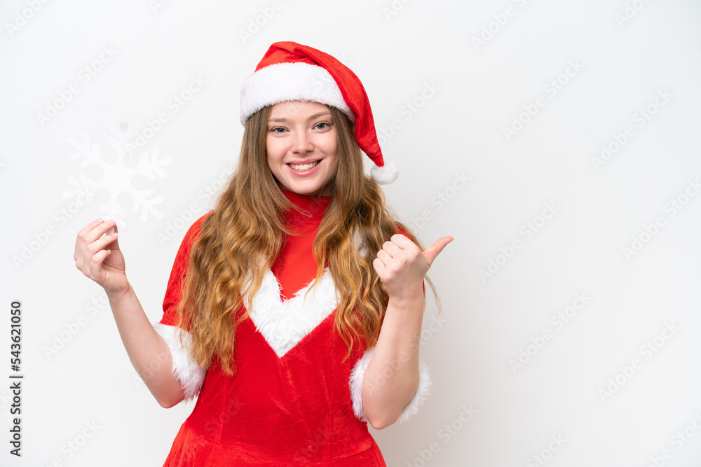 Young caucasian woman with Christmas dress holding snowflake isolated on white background pointing to the side to present a product Young caucasian woman with Christmas dress holding snowflake isolated on white background pointing to the side to present a product
