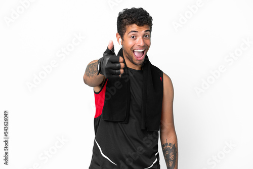 Sport brazilian man with towel isolated on white background with thumbs up because something good has happened © luismolinero