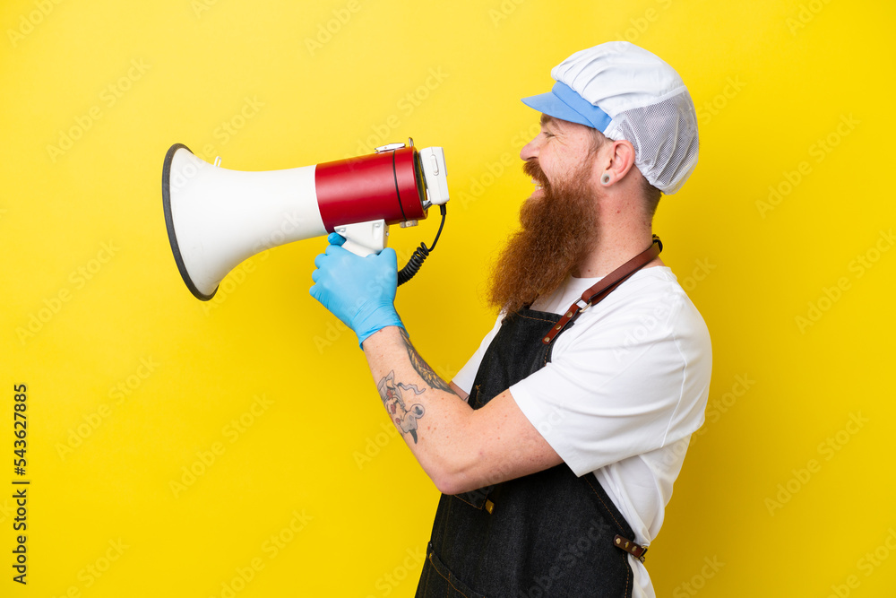 Fishmonger wearing an apron isolated on yellow background shouting through a megaphone Fishmonger wearing an apron isolated on yellow background shouting through a megaphone