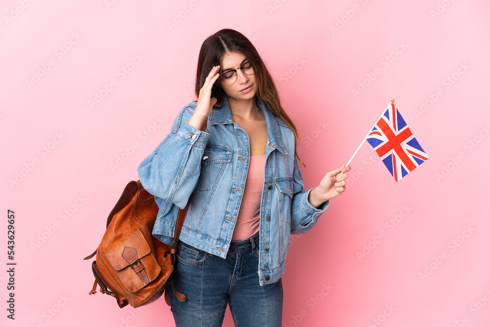 Young woman holding an United Kingdom flag isolated on pink background with headache Young woman holding an United Kingdom flag isolated on pink background with headache