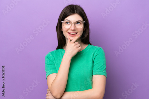 Young pretty Russian woman isolated on purple background With glasses and thinking while looking up