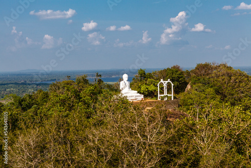 White Buddha statue opn top of a hill in Mihintale, Sri Lanka, Asia photo