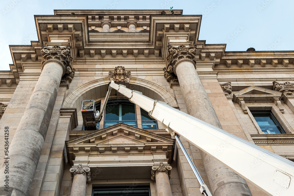 Fototapeta premium Cleaner worker using a cherry picker to clean the windows of the Reichstag in Berlin
