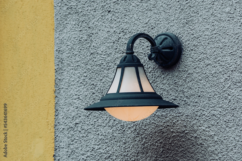 Outdoor lamp hanged on the exterior wall with a dim light