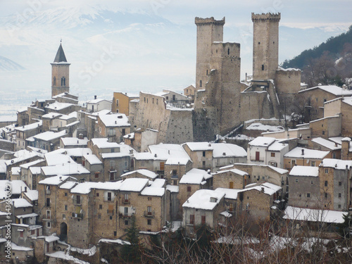 Snowy view of Pacentro and the Caldora or Cantelmo castle that dominates the houses of the characteristic mountain town - Abruzzo - Italy photo