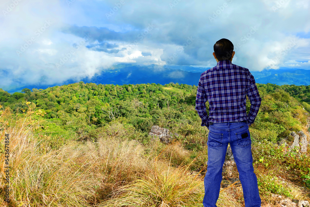 portrait handsome man standing on the mountain and looking distant over the sky with a clouds morning adventure trip concept. portrait handsome man standing on the mountain and looking distant over the sky with a clouds morning adventure trip concept.