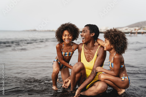 Happy African family having fun on the beach during vacations - Lovely family lifestyle concept