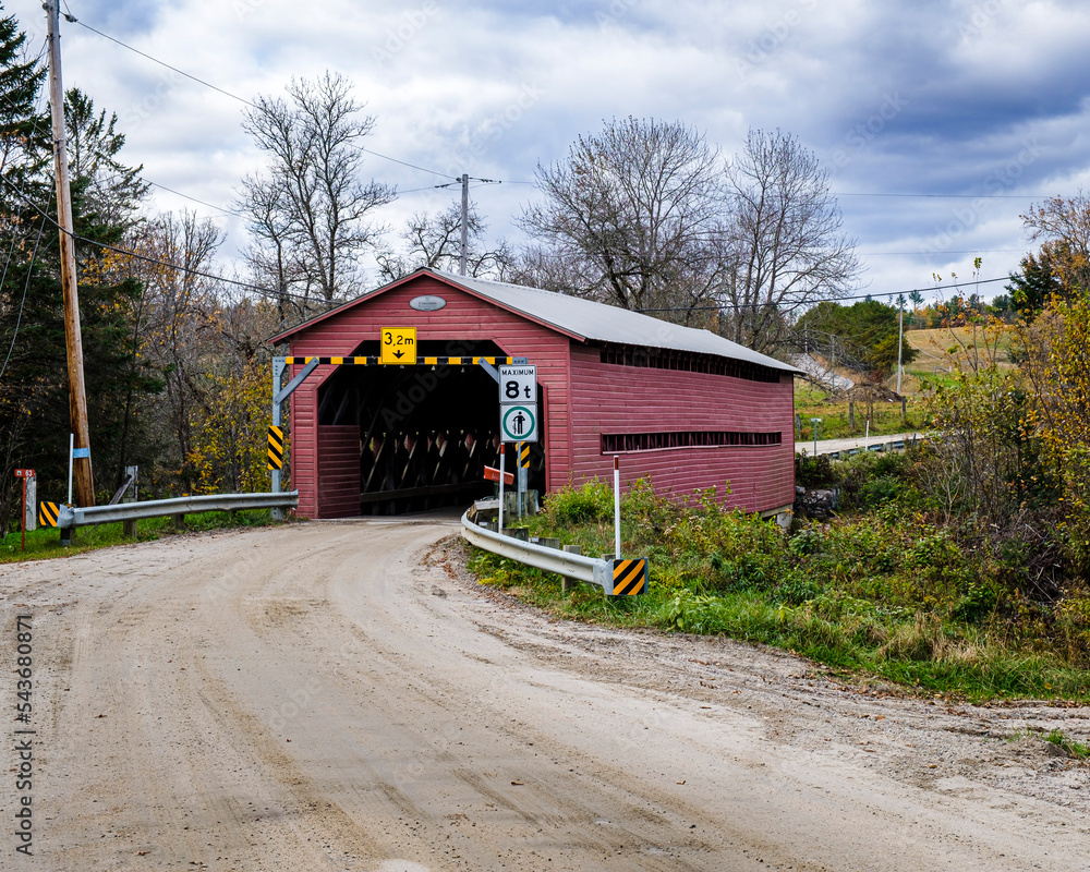 Obraz premium Traditional covered bridge built in the 1930's and known as the Cousineau bridge. Located in Gracefield Quebec, Canada, it spans the Picanoc River.