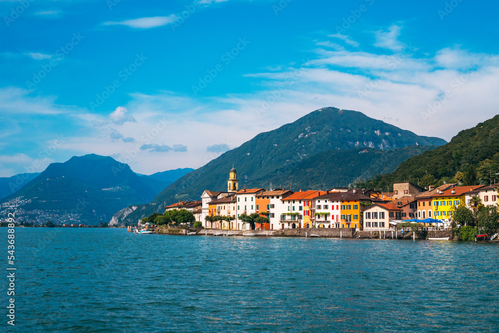 Panoramic view of the ancient lakeside village of Brusino Arsizio, located at the foot of Monte San Giorgio, on the shores of Lake Lugano, Ticino, Switzerland. 