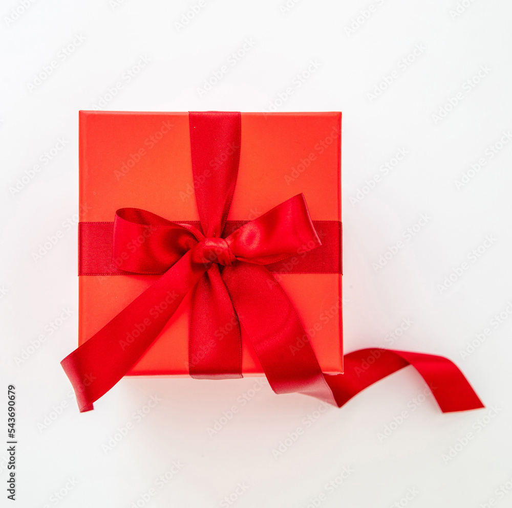 Red gift box with red passion ribbon isolated cutout on white background, top view.