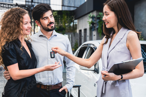 Fotografie Couple picking up car from garage sales woman returning car keys to customers