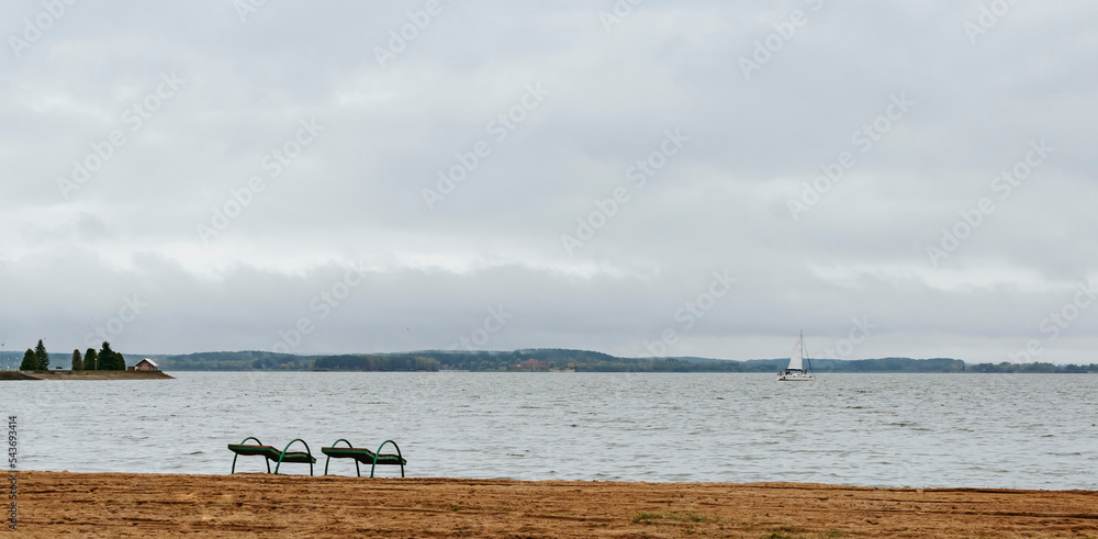 An empty beach on the shore of the lake in autumn