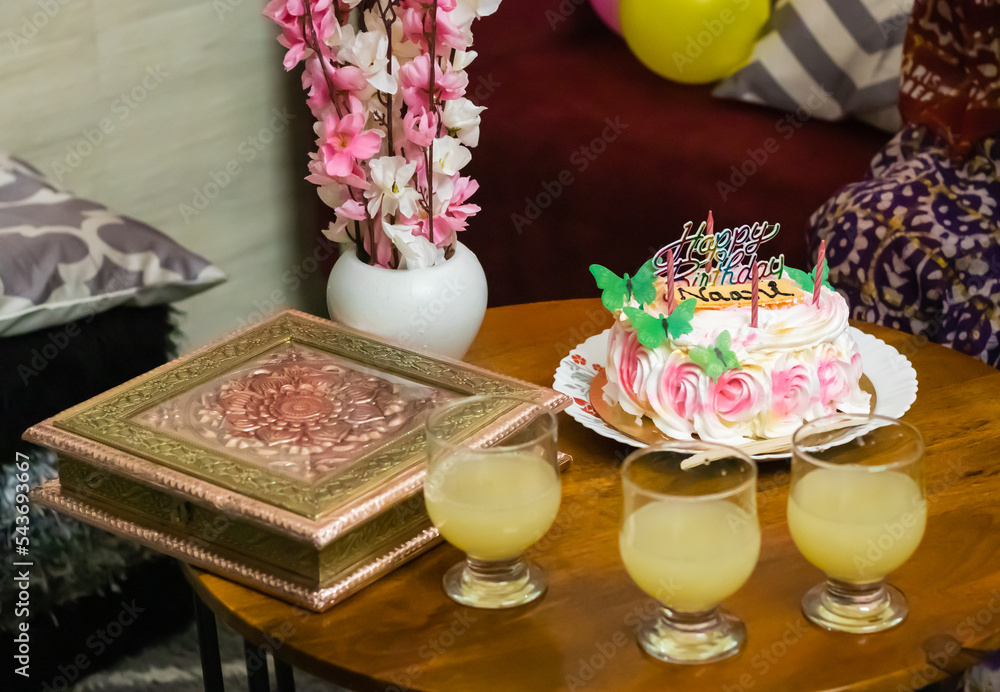 maternal grandmother birthday cake decorated with candles and juice glasses at coffee table