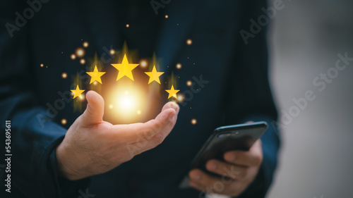 Service rating, satisfaction concept.hand of customer or client holding the stars to complete five stars. with copy space. giving a five star rating.