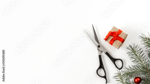 Christmas composition. Hairdressing scissors and a spruce branch on a white background. Template for a postcard or information about a hair salon. Flat lay, copy space.