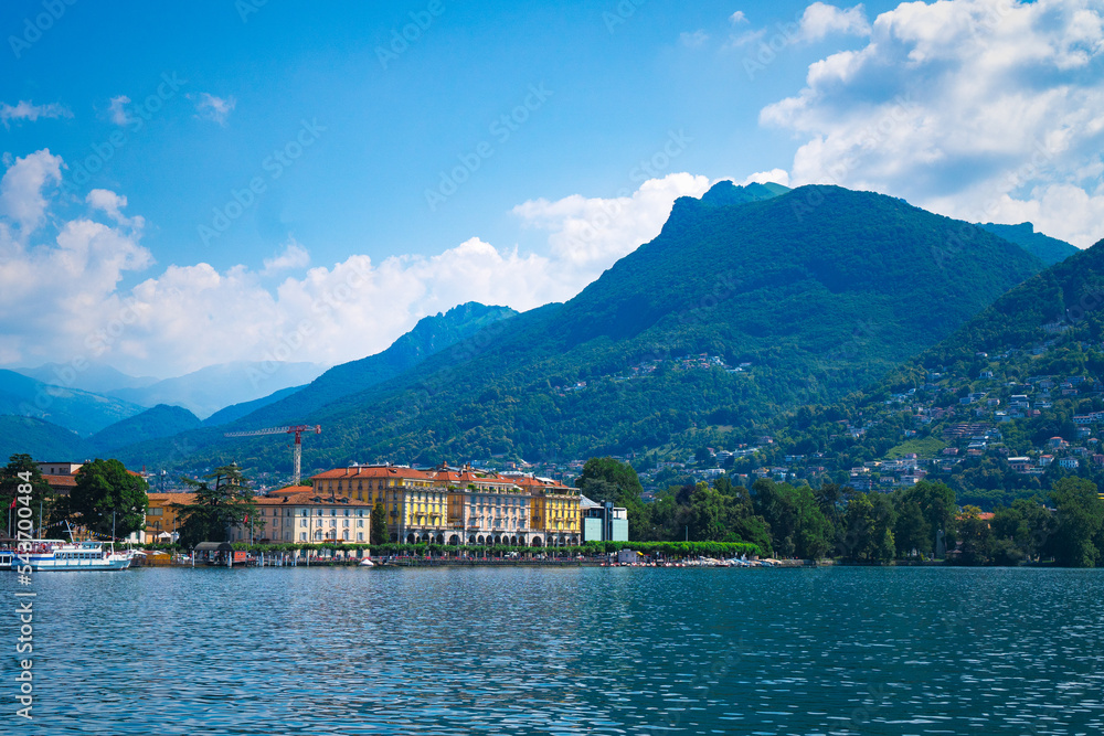 Stunning landscape of picturesque Lake Lugano and the green lush Swiss Alps in the distance. Idyllic town Lugano, Switzerland,  on a sunny summer day.