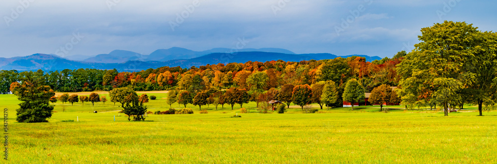 Fototapeta premium banner of Vermont farm meadows and fields in Autumn with the New York Adirondack Mountains in the distance 