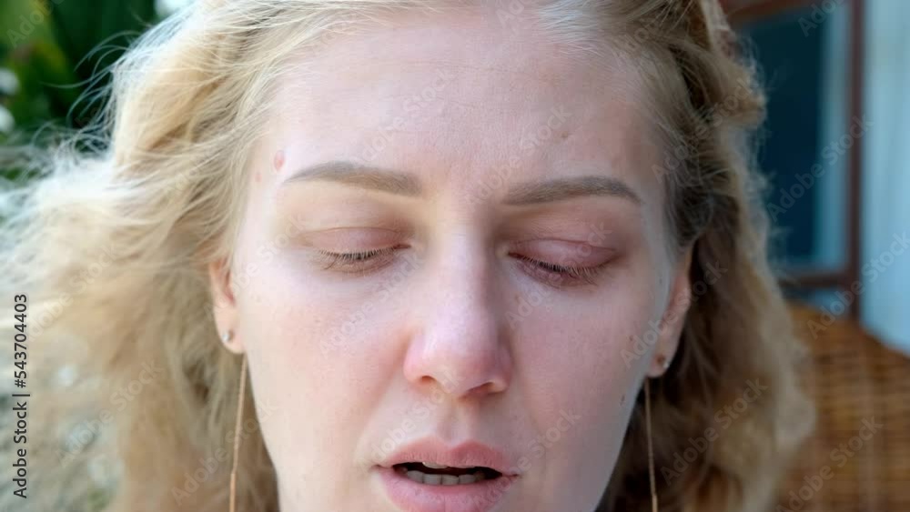 Portrait of tired sick woman with blue eyes looking at camera. Woman