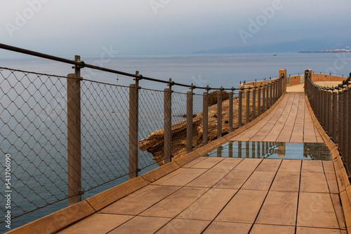 Jolucar suspension footbridge, in Torrenueva Costa, Granada, view of the wooden footbridge and with a part of the floor in transparent glass, and the Mediterranean sea in the background. photo