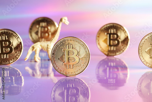 Golden bitcoin coins with dinosaur on neon background. digital currency, business style. Mining and trade bitcoin, evolution concept. photo