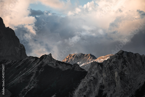 The peak of the alps in the Northern Italy receive the last light of the day, with a moody sky photo