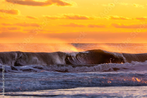 Spray from large waves in rough surf being lit up with golden light at sunset. Long Island New York © Scott Heaney