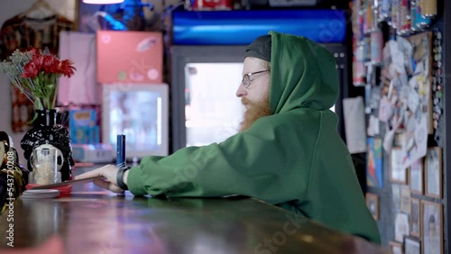 Bearded bartender cleans beer tap