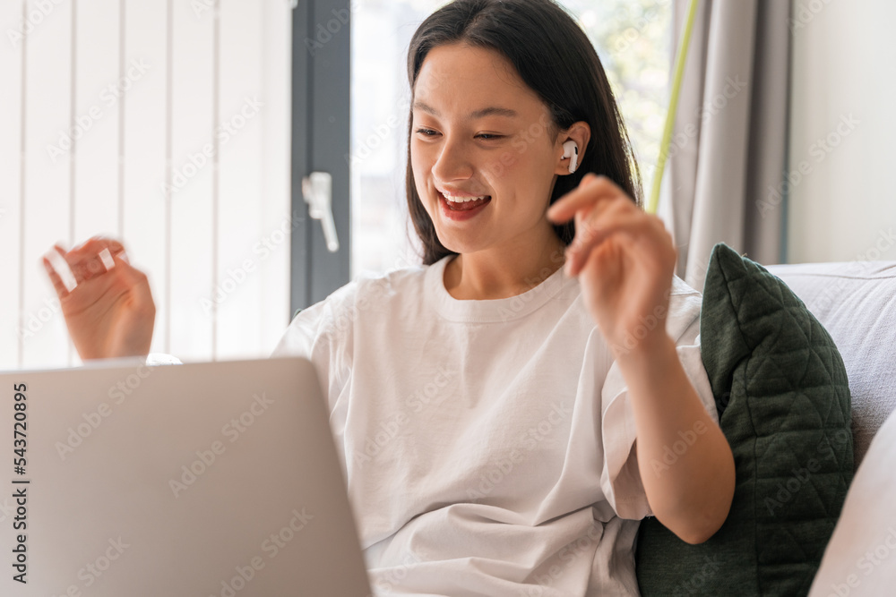 Portrait view of the beautiful smiling lady wearing earphones talking with friend through video call Portrait view of the beautiful smiling lady wearing earphones talking with friend through video call