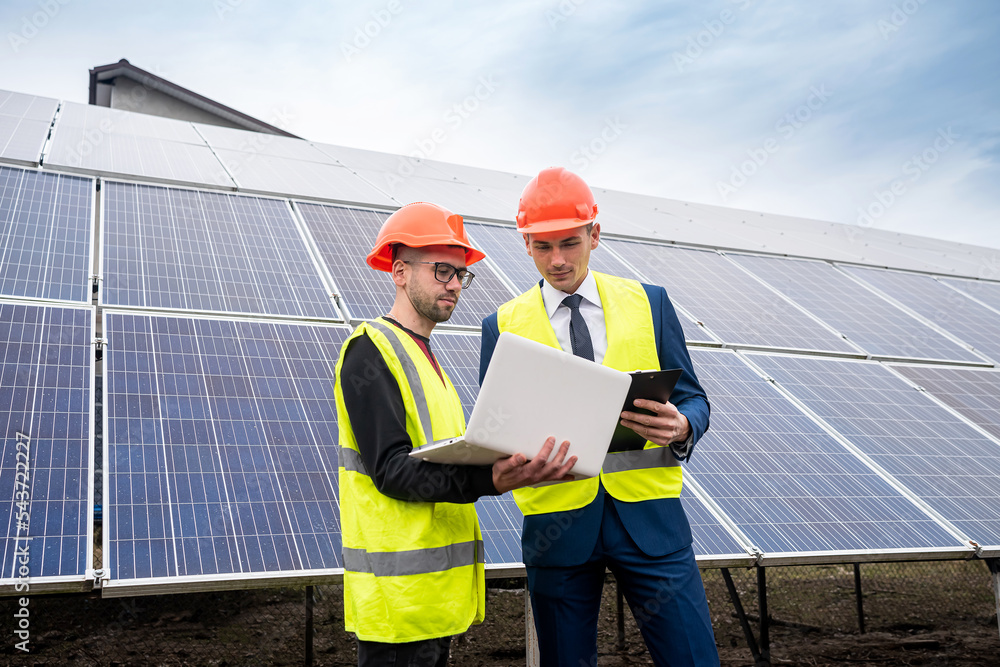 the director of company inspects the work of an employee in clothing installed solar panels. the director of company inspects the work of an employee in clothing installed solar panels.