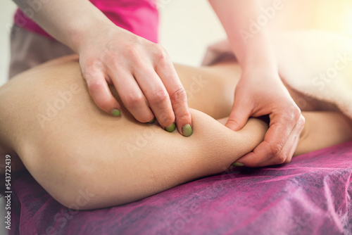 close up of female hands make therapeutic massage for woman client relaxing on table in spa salon