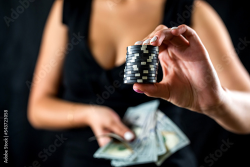 beautiful female player counts chips for money and raises during poker game in casino.