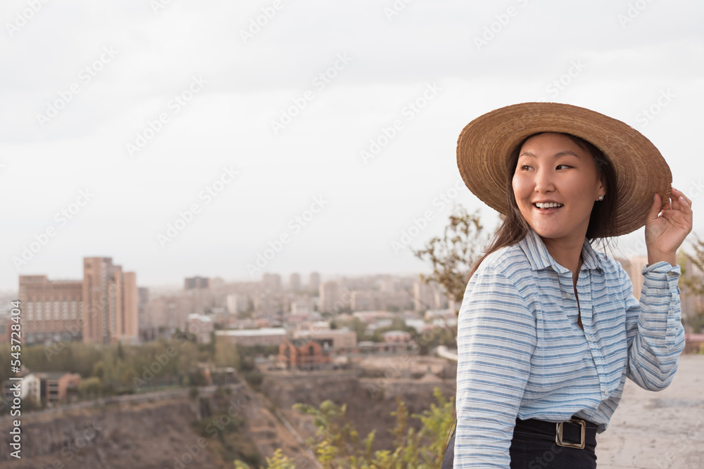 Young asian siling woman in hat outdoors in summer