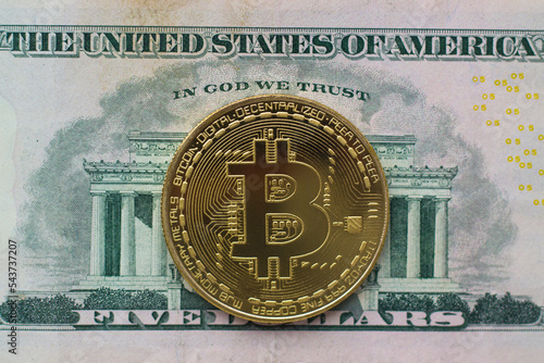 Bitcoin coin on dollar bill closeup