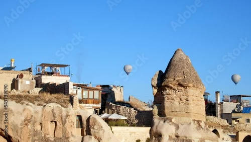 Hot air balloons fly above cave hotels and fairy chimneys. Goreme, Nevsehir province, Turkey. Cappadocia, UNESCO World Heritage site photo