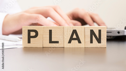man made word plan with wood blocks on the background of the office table. selective focus. business concept.
