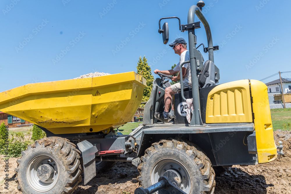 Fototapeta premium Bauarbeiter auf Baustelle mit Dumper