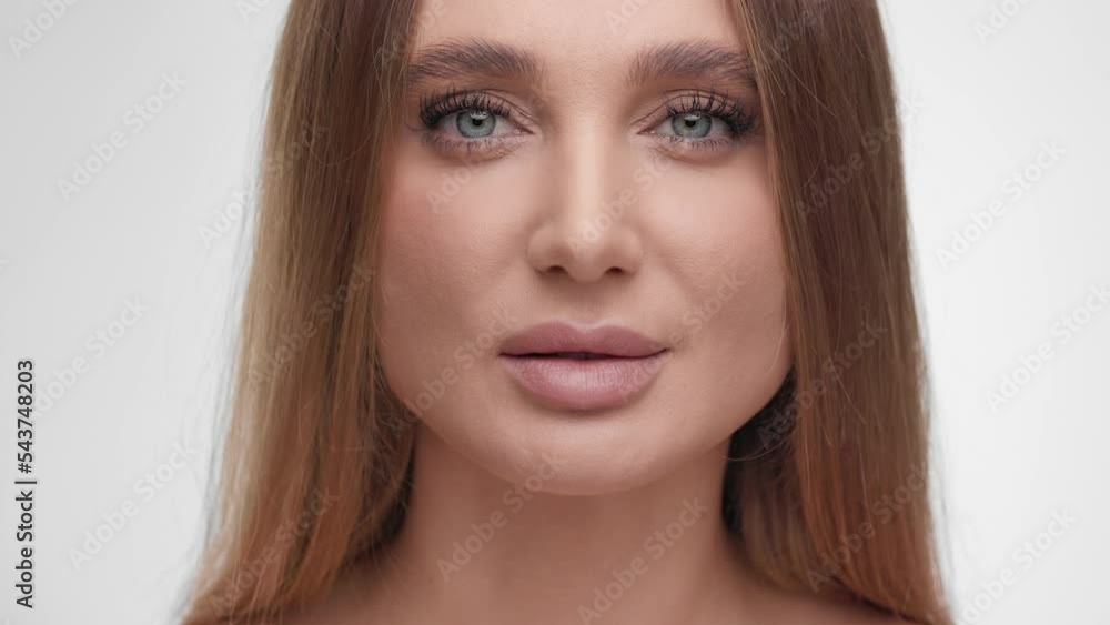 Skin care concept. Close up beauty woman face with green eyes. Beautiful female model with smooth healthy fresh skin looking at camera and smiling.