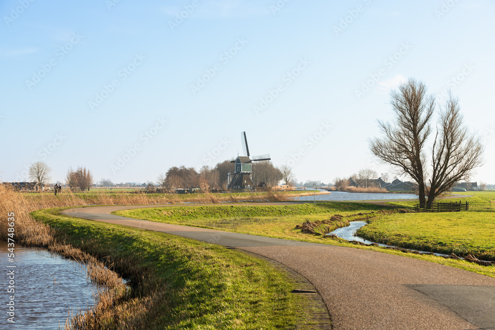Polder landscape near the village of Groot-Ammers with the 16th century Achterlandse Molen in the background along the water of the Ammersche Boezem in South Holland.