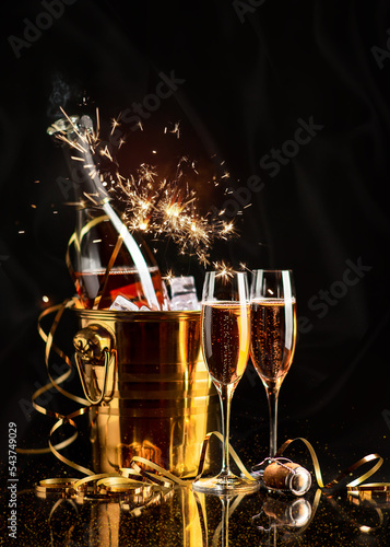 Obraz na płótnie Golden Bucket with champagne, two glasses and a golden serpentine on a black background w salonie