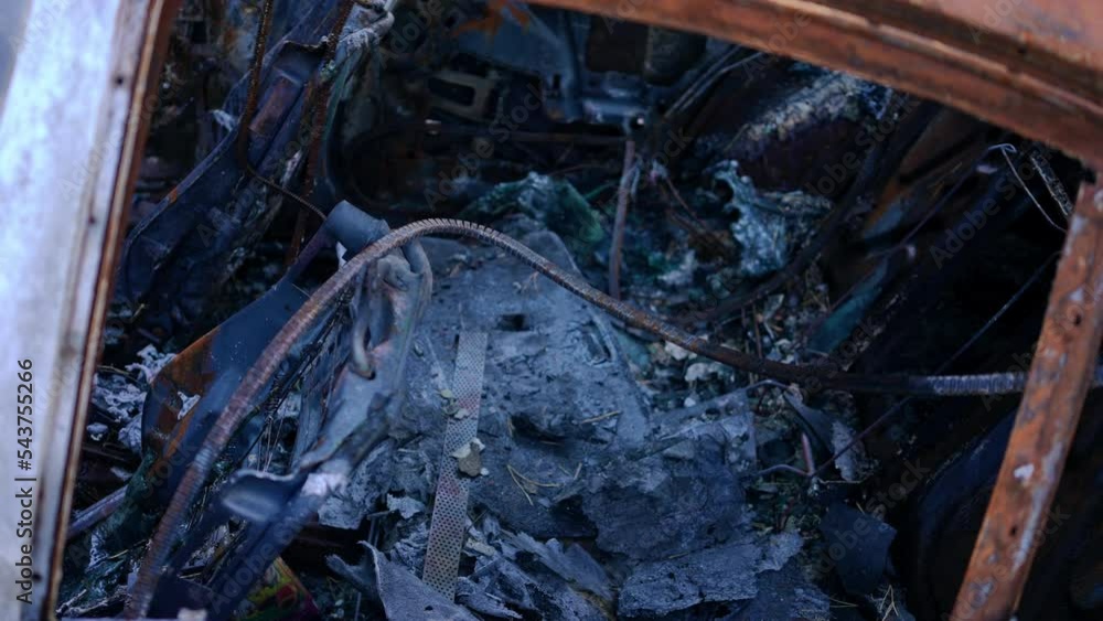 Side view burnt down back seat in car close-up. Demolished destroyed automobile interiors. Concept of bombing and war consequences Side view burnt down back seat in car close-up. Demolished destroyed automobile interiors. Concept of bombing and war consequences