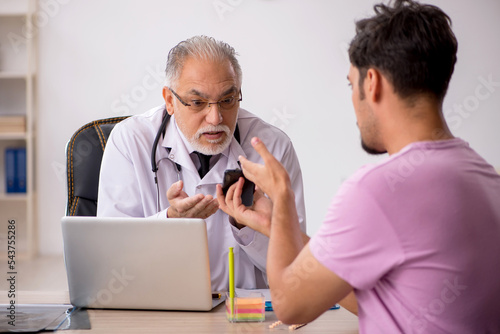 Young male patient visiting old male doctor