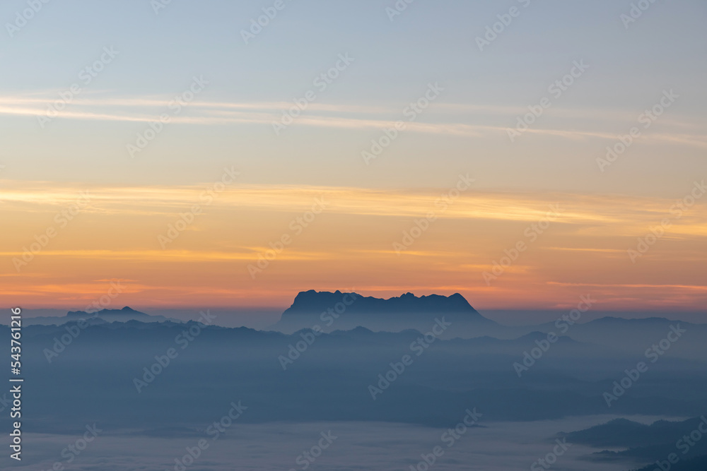 Mountain and mist in morning sunrise orange sky background. Doi Luang Chiang Dao mountains in thailand.