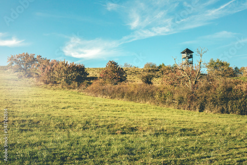 Fototapeta Naklejka Na Ścianę i Meble -  Watchtower on the green meadow on a sunny day.Autumn landscape.