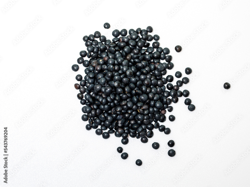 Handful of black lentils isolated on white background. Dry beluga lentil grains pattern, raw dal, daal, dhal, masoor, pulse wallpaper with copy space. Top view from above Handful of black lentils isolated on white background. Dry beluga lentil grains pattern, raw dal, daal, dhal, masoor, pulse wallpaper with copy space. Top view from above