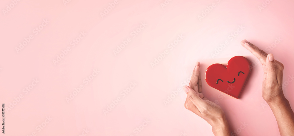 Hand cover protect red smiling shape for good wellbeing, happiness life with good mental health, charity and support positive emotion feeling concept Hand cover protect red smiling shape for good wellbeing, happiness life with good mental health, charity and support positive emotion feeling concept