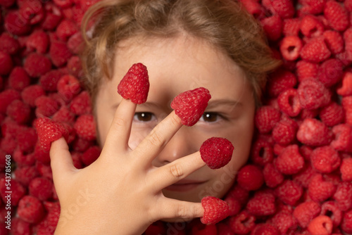 Fresh raw raspberry near kids face. Raspberri macro. Top view of collection raspberries. Raspberries background.